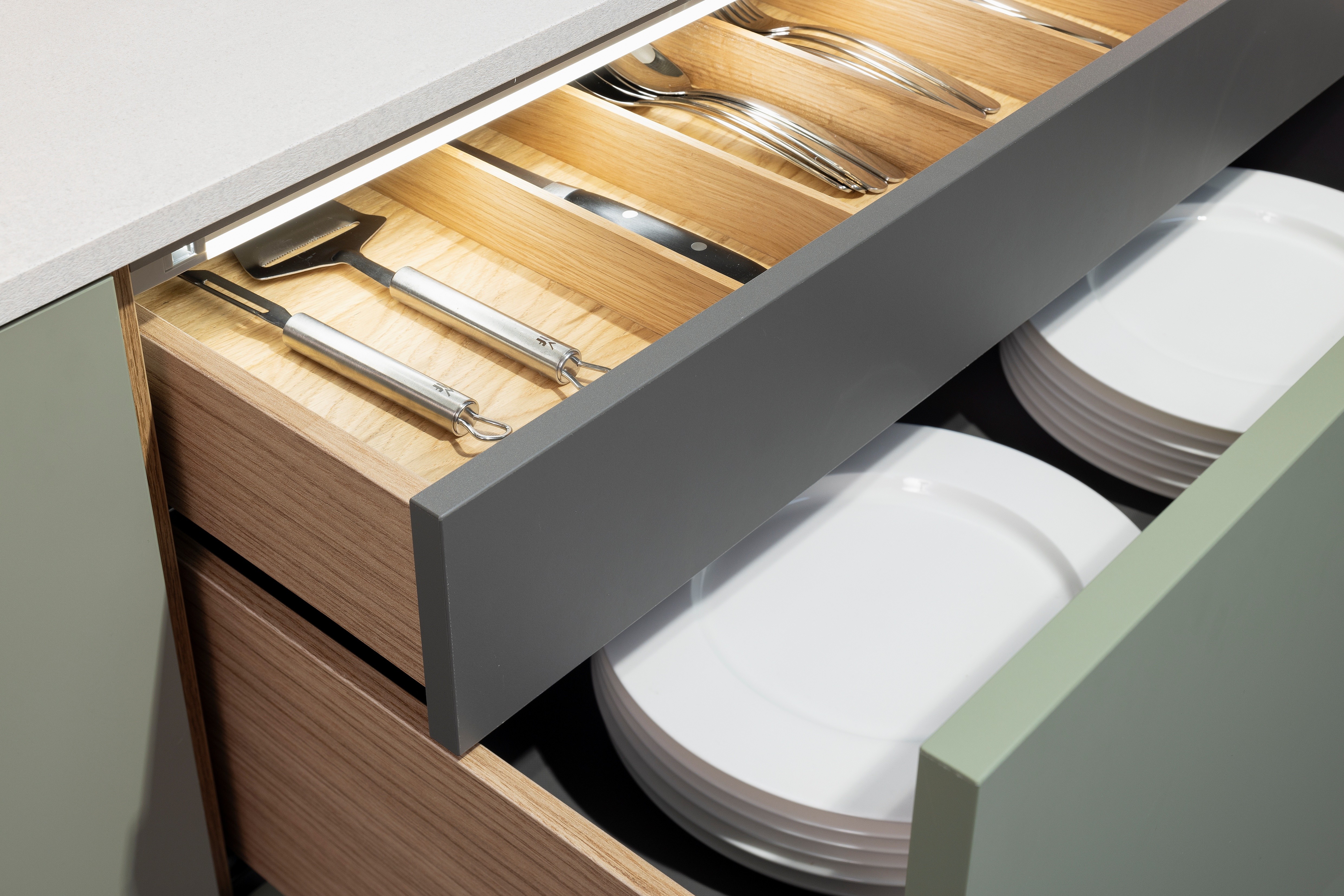 APL: 794 Beton Seidengrau NB (Xtra Ceramic) Korpus: 198 Eiche Sierra Front: Senso 495 Lack, Olive Premium matt Geräte: Neff Slide&Hide Armatur: Gessi  Spüle: Teka  Features: Trendfarbe Olive, Push to open, Tapete, neuer Schubkasten, Wandeinbau Backofen, beleuchtete Regale, beleuchtete Vitrinen, Weinflaschenregal, Schubkästen und Korpus in Eiche Sierra, Premium matte Oberfläche mit Antifingerprint, Nischenrückwand in Rillenoptik.