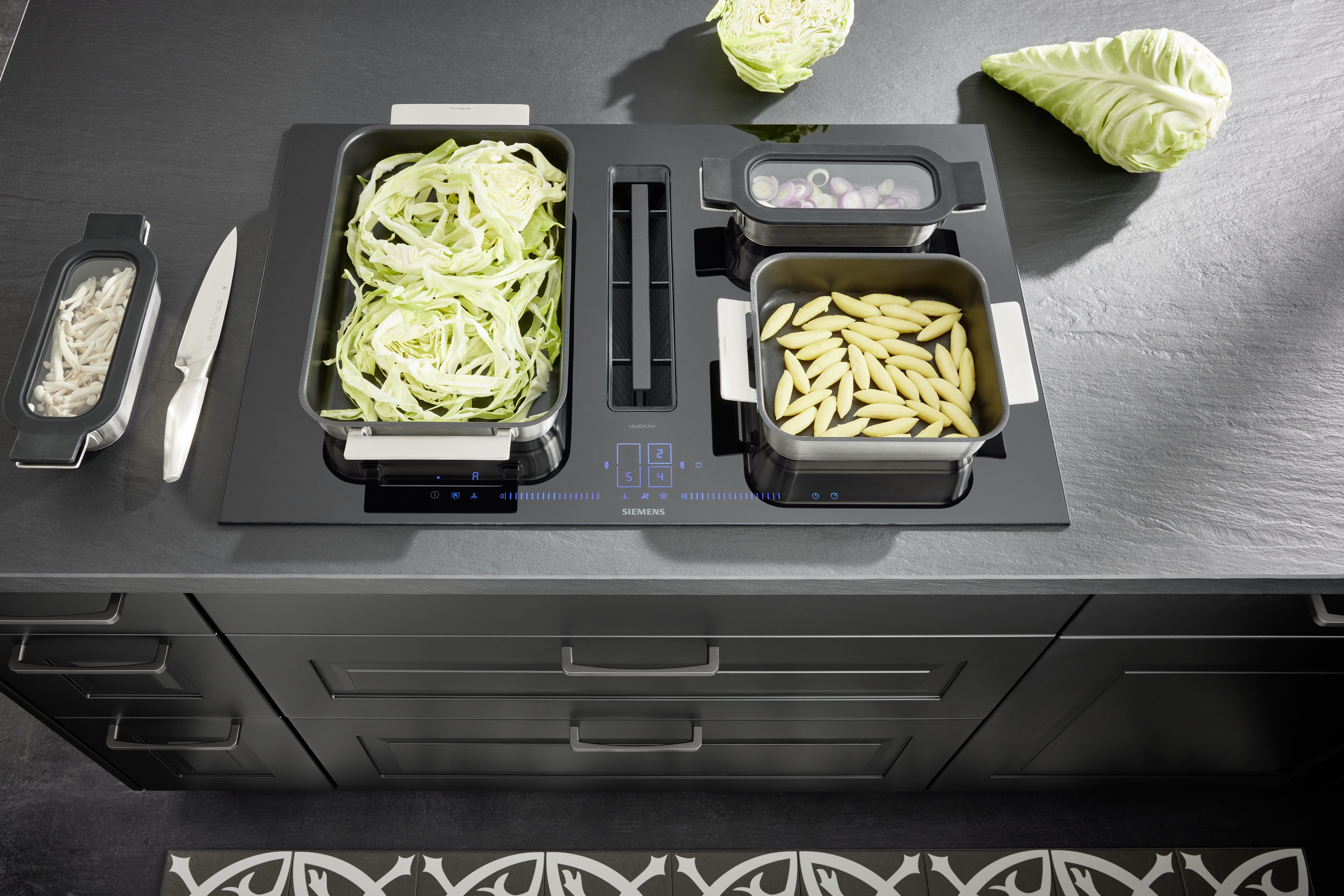 NOBILIA Sylt schwarz mit Siemens Geräten - Fokus auf Kochfeld mit Muldenlüftung und blauer LED-Anzeige